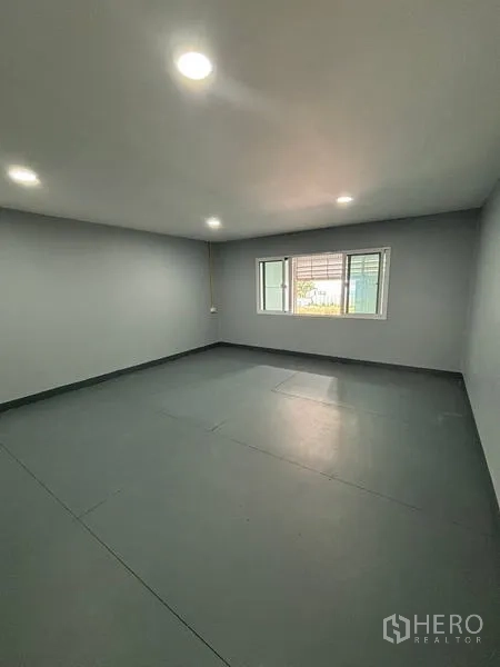 货栈 出租在Mueang Pathum Thani, Pathum Thani - 临街视角的仓库立面，多个仓门与雨棚下停车位。