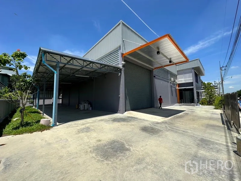 โรงงาน ให้เช่าหรือขายในLam Luk Ka, Pathum Thani - ภายนอกโรงงานสมัยใหม่ที่ลำลูกกา มีประตูม้วนสูง หลังคาคลุมช่องโหลด และลานคอนกว้าง.