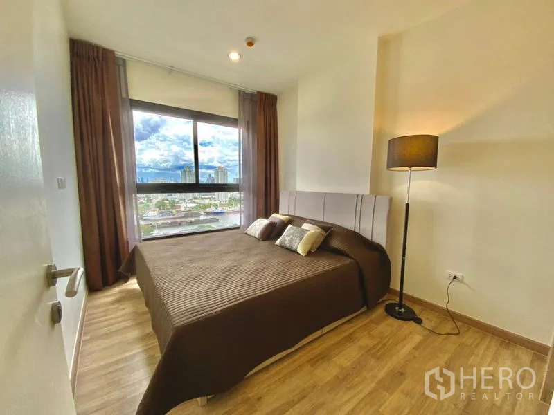 คอนโด ให้เช่าหรือขายในThon Buri, Bangkok - ห้องนอนใหญ่พื้นไม้ โคมไฟยืน วิวเมืองและแม่น้ำ