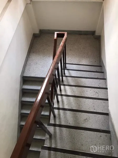 Townhouse for rent in Khlong Toei, Bangkok - Internal stairway with wooden handrail and anti-slip steps.