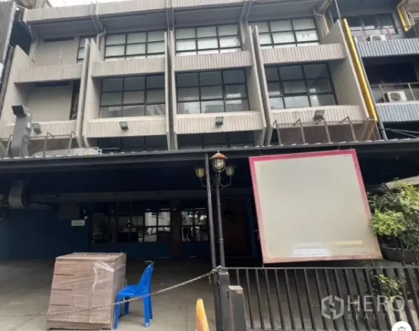 零售空间 出租 - 多层建筑外立面，大窗与店前遮雨空间。