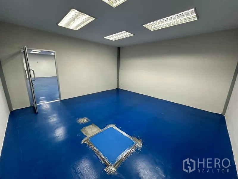 Office Space for rent - Enclosed blue-floor room with service hatch in the center.