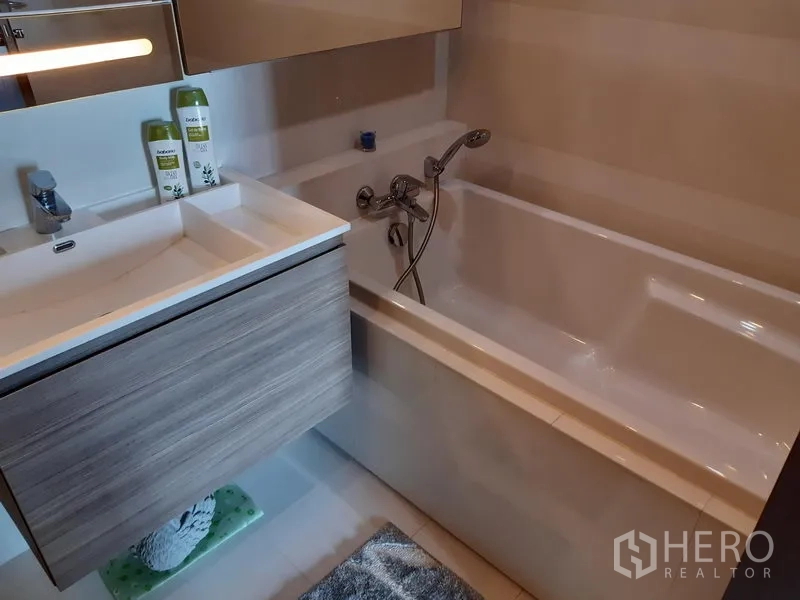 公寓 出租在Khlong Toei, Bangkok - 浴室配备全尺寸浴缸与壁挂式洗手台储物柜。