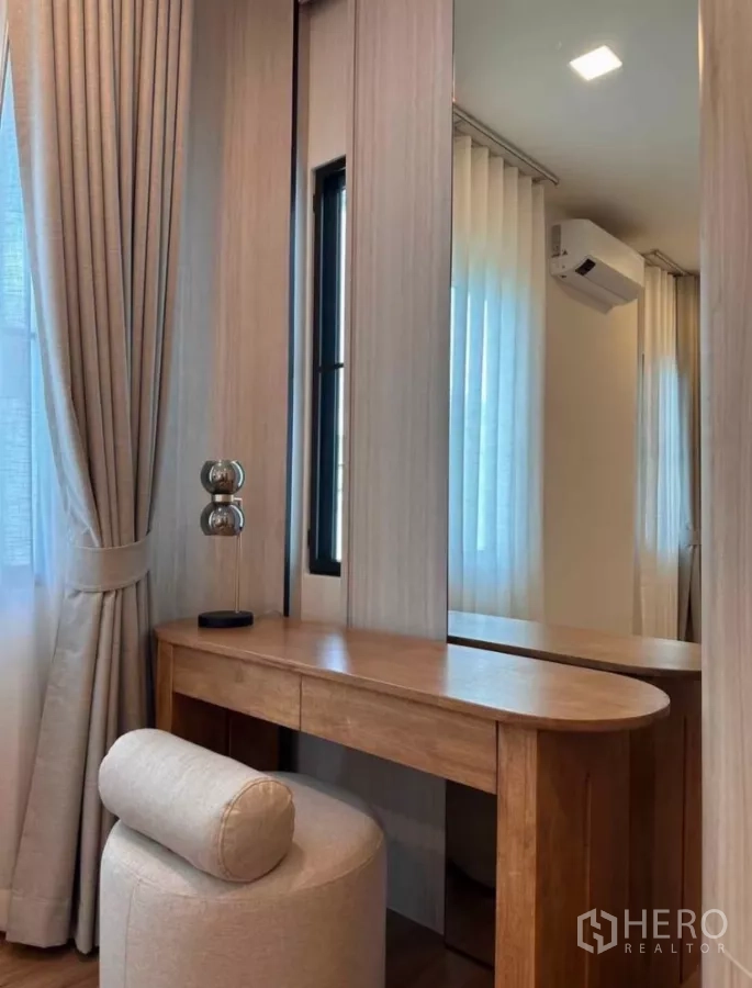 Detached House for rent in Samut Prakan - Dressing vanity with tall mirror, curtain-lined window, and cushioned stool.