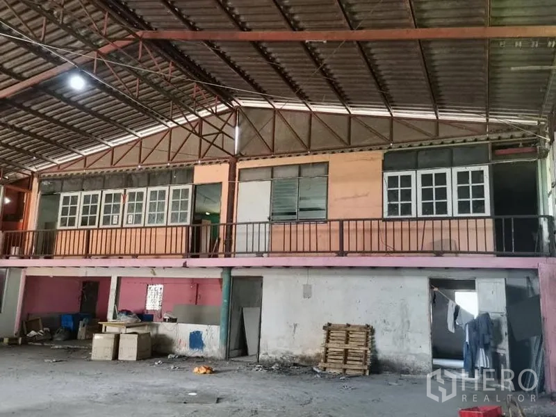 คลังสินค้า ให้เช่าในLam Luk Ka, Pathum Thani - มุมมองใกล้ของชั้นลอยออฟฟิศและราวกันตก ใต้หลังคาโครงเหล็กภายในโกดัง