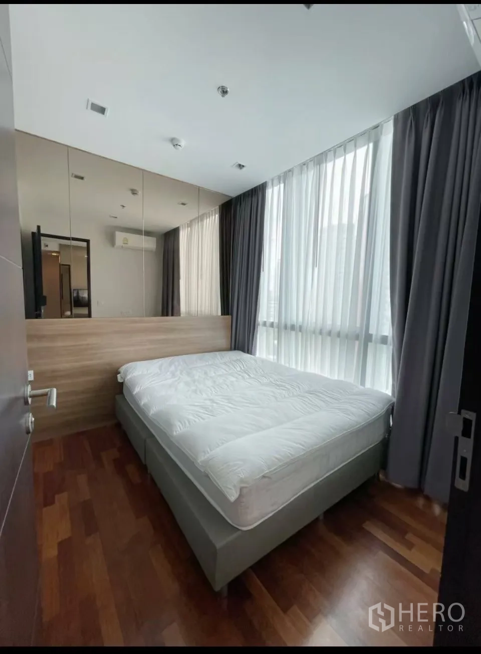 คอนโด for rent in Ratchathewi, Bangkok - ห้องนอนอบอุ่นเตียงขนาดใหญ่ ผนังกระจกเงา และม่านโปร่งยาว