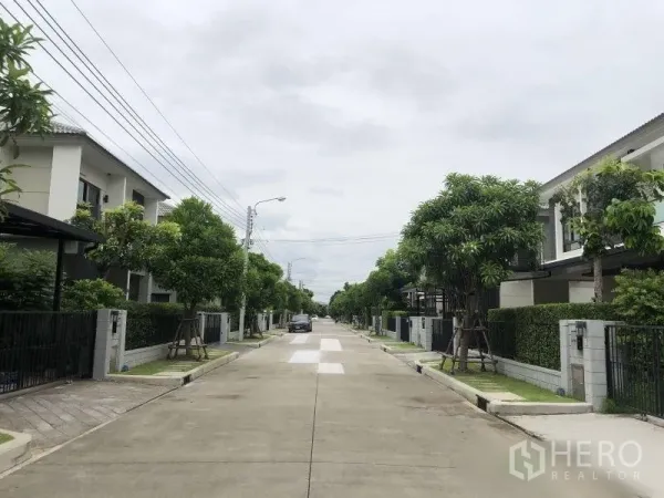 Detached House for sale in Bang Phli, Samut Prakan - Tree-lined private estate road with contemporary houses and sidewalks