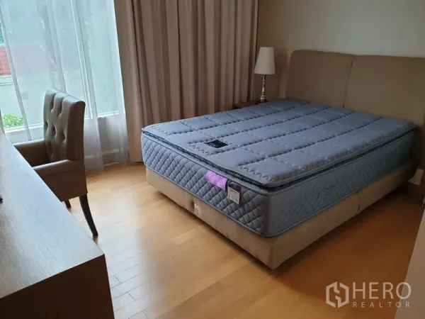 Condominium for rent in Watthana, Bangkok - Third bedroom with double bed, study desk, bedside lamp and abundant natural light.