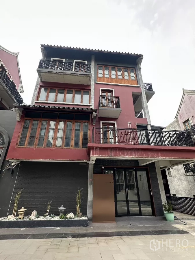 带办公室的家 出租在Pathum Wan, Bangkok - 四层转角家用办公楼外立面，红色墙面，带阳台与一层玻璃门