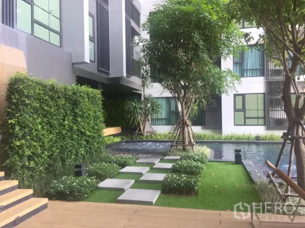 公寓 出租在Khlong Toei, Bangkok - 公寓景观庭院，踏步石、垂直绿墙与水景池。