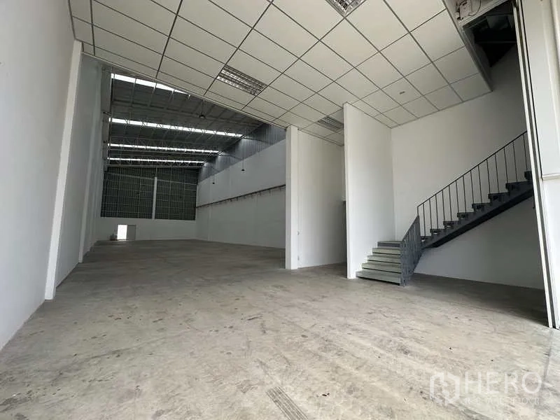 Factory for rent in Khlong Luang, Pathum Thani - Spacious production hall with high ceiling, skylights, reinforced floor, and mezzanine office with stairs.