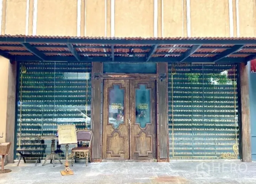 零售空间 出租在Watthana, Bangkok - 复古风门面，木质双开门与整面玻璃橱窗，配金属雨棚的商铺外立面。