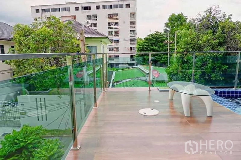 บ้าน ขายในLat Phrao, Bangkok - ชานระเบียงริมสระ พื้นไม้ลามิเนต ราวกันตกกระจก วิวชุมชนโดยรอบ