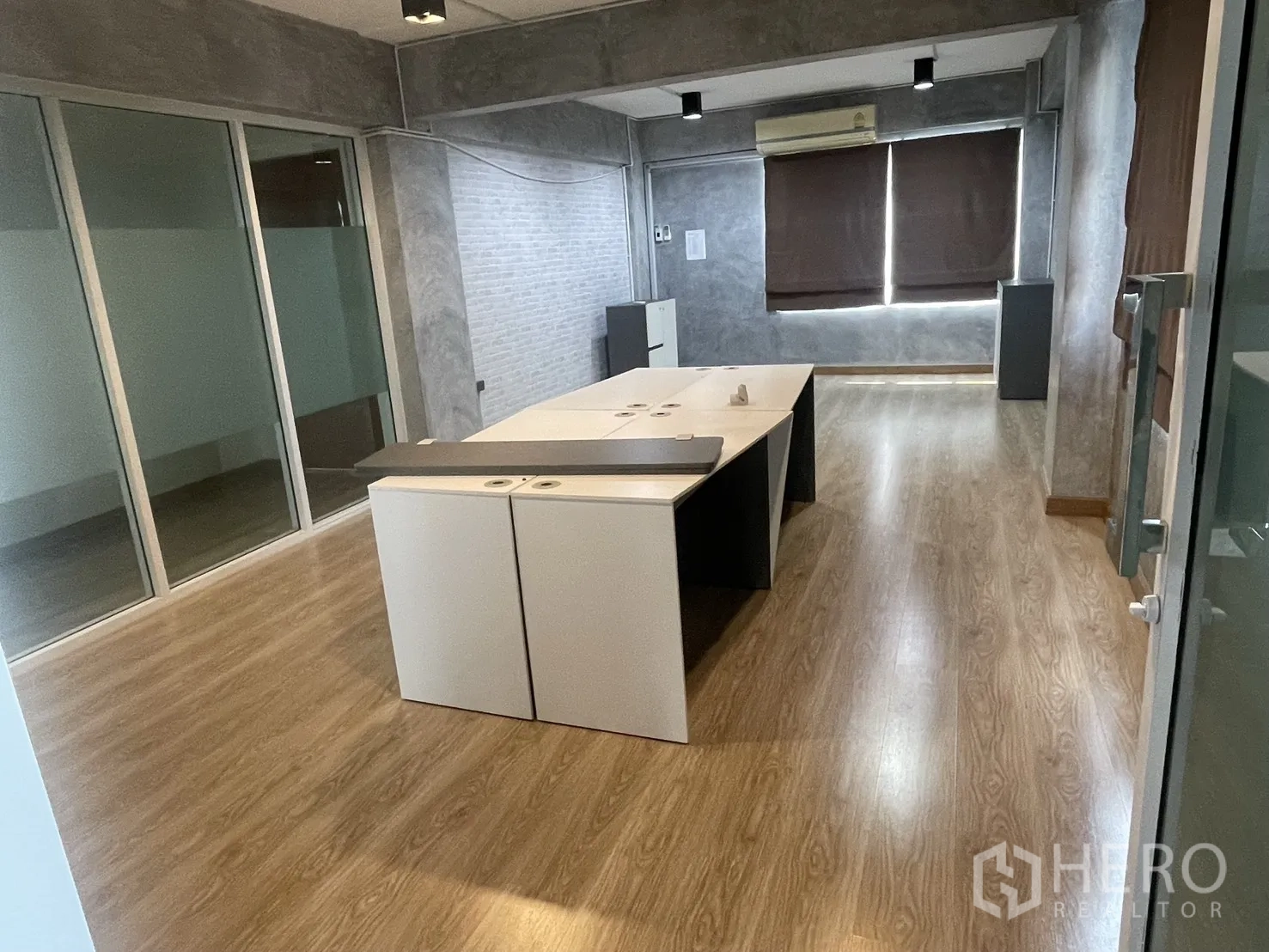 Home Office for rent in Suan Luang, Bangkok - Glass-partitioned office with desks, laminate flooring, and blackout blinds.