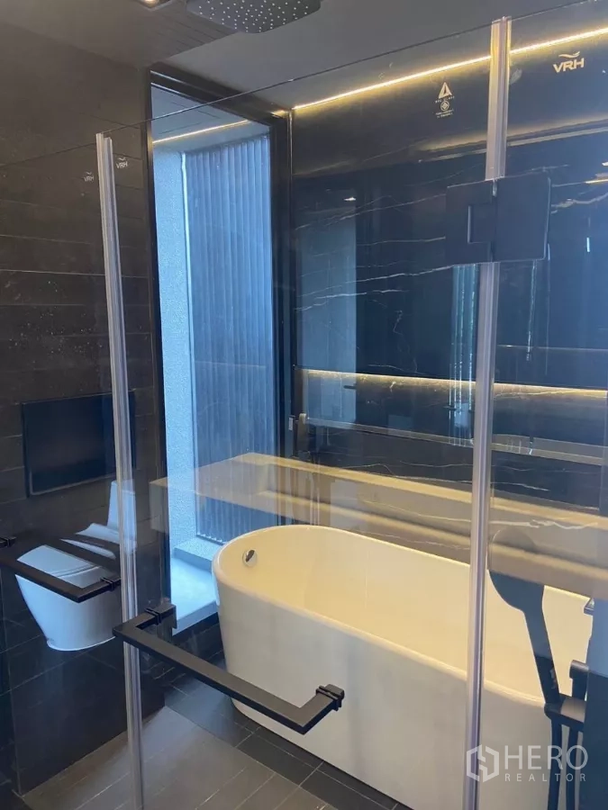 ทาวน์เฮาส์ ให้เช่าในHuai Khwang, Bangkok - ห้องน้ำกั้นกระจกพร้อมอ่างลอยตัวและเรนชาวเวอร์บนเพดาน.