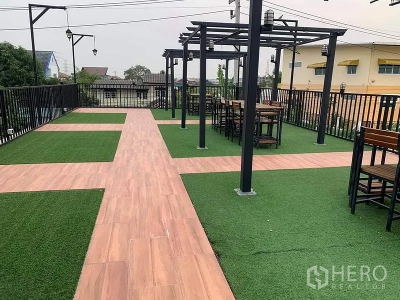 Shophouse for sale in Lam Luk Ka, Pathum Thani - Rooftop terrace with pergola structures, seating and artificial grass.