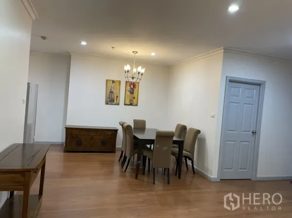 公寓 出租在Watthana, Bangkok - 用餐区配六人餐桌、吊灯和墙面装饰画。