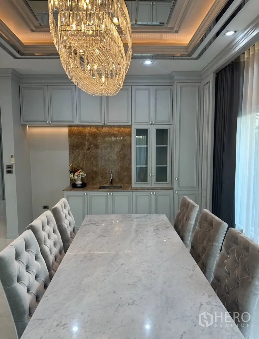 บ้านเดี่ยว for rent or sale in Prawet, Bangkok - พื้นที่ทานอาหาร โต๊ะท็อปหินอ่อน เก้าอี้ทัฟต์ และตู้บิวท์อินพร้อมมุมบาร์ล้าง