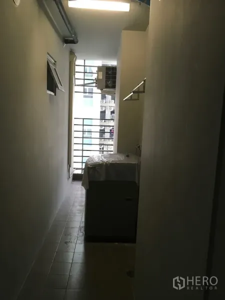 Condominium for rent in Huai Khwang, Bangkok - Utility balcony with tiled floor, washing machine and metal railings for ventilation.