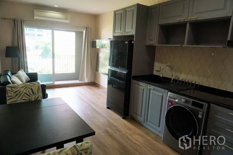 คอนโด ขายในKhlong Toei, Bangkok - ห้องนั่งเล่นสว่างพร้อมประตูกระจกบานเลื่อนออกสู่ระเบียงและครัวเต็มรูปแบบ