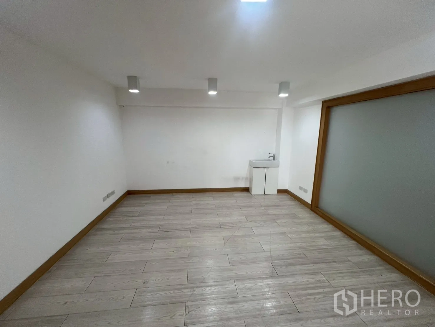 พื้นที่ขายของ for rent in Watthana, Bangkok - ห้องกว้างพื้นลายไม้ ไฟฝังฝ้า และอ่างล้างมือขนาดเล็ก