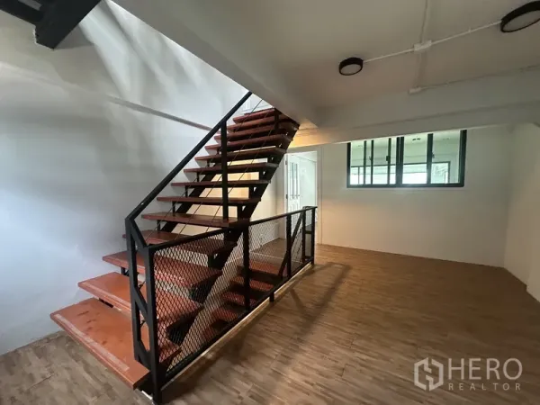Home Office for rent or sale in Khlong Toei, Bangkok - Industrial‑style steel staircase with mesh balustrade in a spacious landing area.