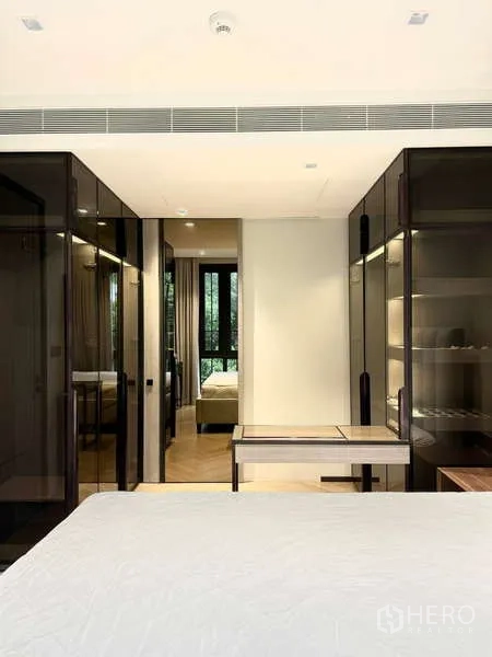 Condominium for rent in Watthana, Bangkok - Bedroom with mirrored glass wardrobes and a built-in dressing desk.