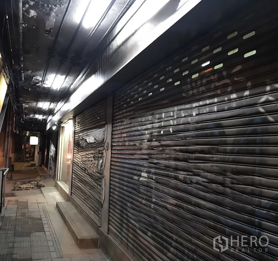仓库 for rent in Phra Khanong, Bangkok - 外部临街金属卷闸门立面，配有顶棚照明。