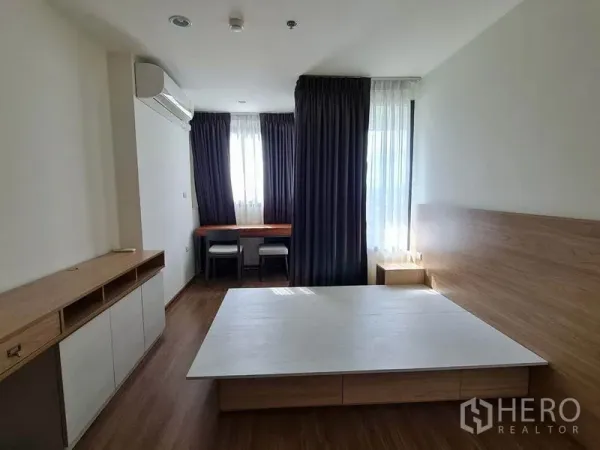 公寓 出租或出售在Yan Nawa, Bangkok - 主卧配平台床、内置柜与书桌，大落地窗与遮光窗帘，位于曼谷Yan Nawa公寓。