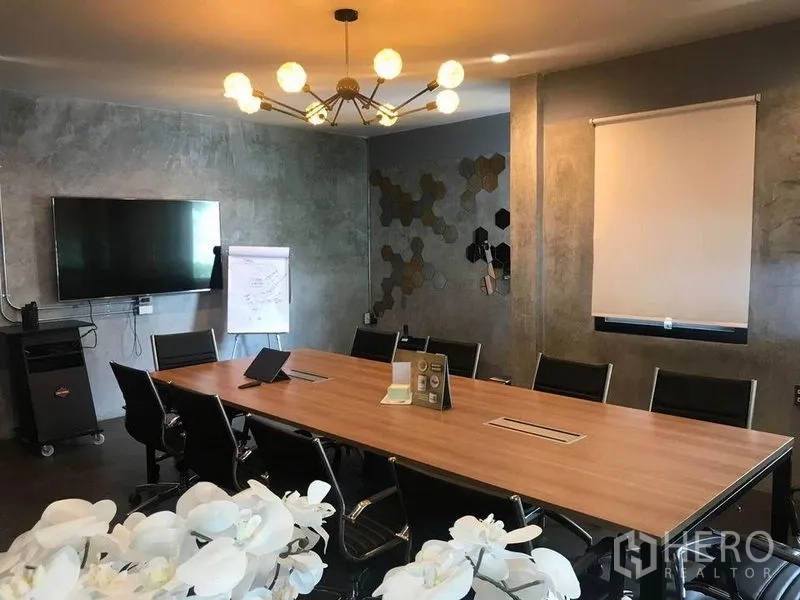 Office Space for rent in Bang Kapi, Bangkok - Boardroom featuring a long meeting table, black chairs, TV screen and modern ceiling light.