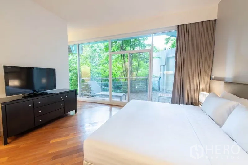 Condominium for rent - Bedroom with king bed, TV console and balcony overlooking lush greenery.