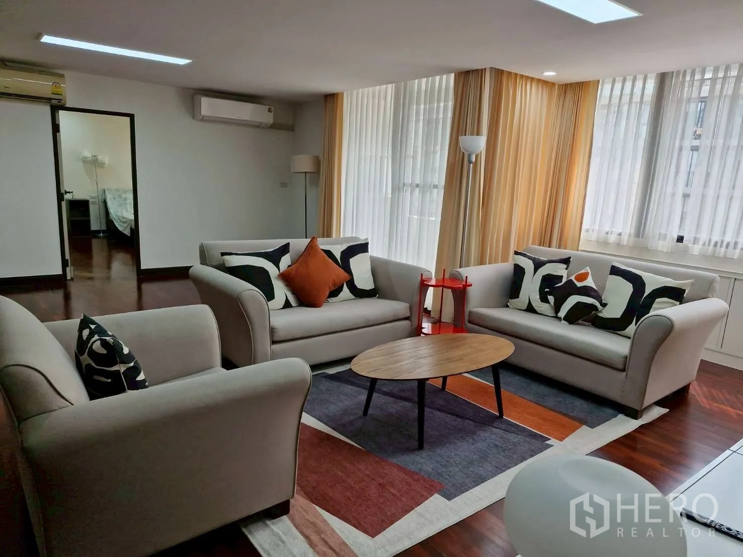 Condominium for rent in Khlong Toei, Bangkok - Living room seating cluster around a coffee table facing the TV unit.