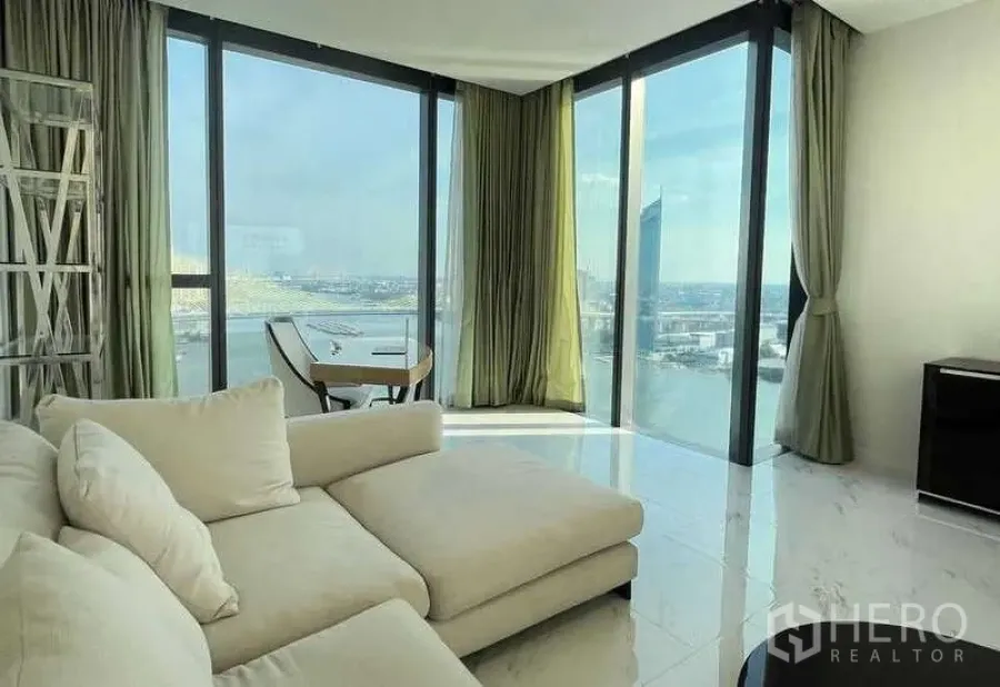 Condominium for rent or sale in Bangkok - Lounge corner with chaise sofa and panoramic corner glass overlooking the river.