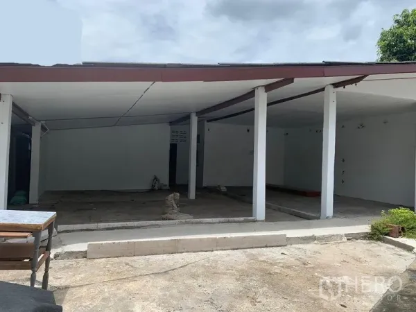 独立式住宅 出租在Phra Khanong, Bangkok - 单层独栋住宅，带半露天廊下、白色立柱与混凝土地面。