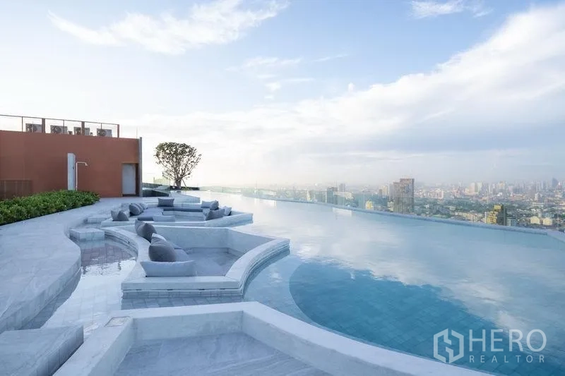 Condominium for sale in Chatuchak, Bangkok - Daytime rooftop infinity pool with built-in sunken lounges and sweeping skyline views.