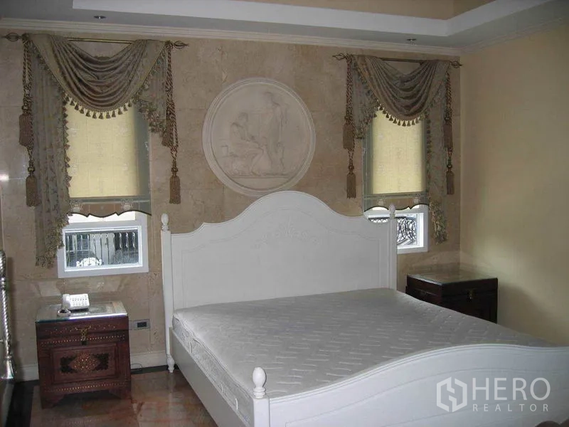 บ้าน ให้เช่าในWatthana, Bangkok - ห้องนอนเตียงสีขาว ผนังลายปูนปั้นทรงกลมและผ้าม่านหรู