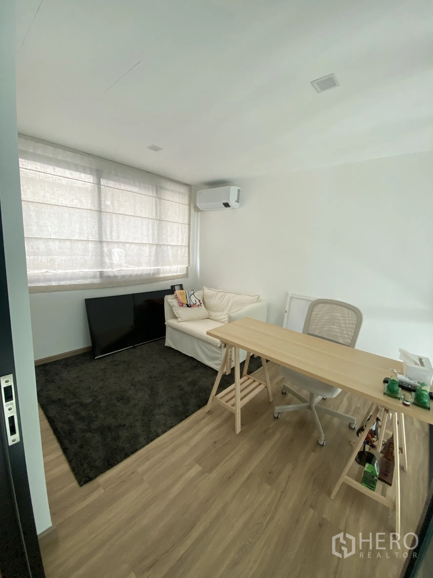 Townhouse for rent or sale in Bang Khae, Bangkok - Cozy study with sofa, desk, and large window blinds