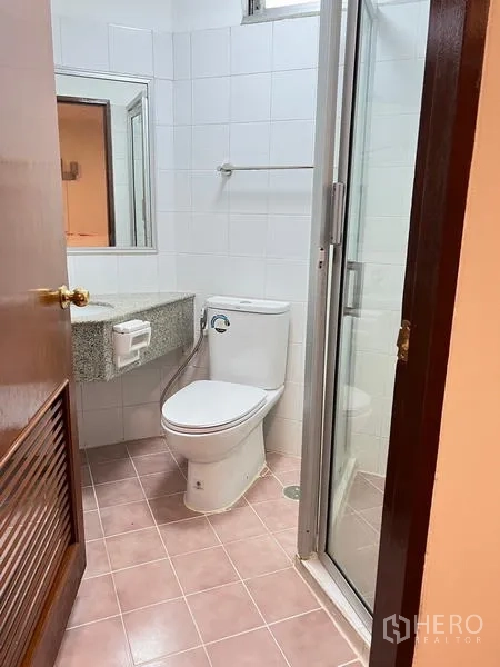 คอนโด ให้เช่าในRatchathewi, Bangkok - ห้องน้ำขนาดกะทัดรัด ปูกระเบื้องสีขาว เคาน์เตอร์หินแกรนิต โถสุขภัณฑ์ และตู้ฝักบัวกระจก