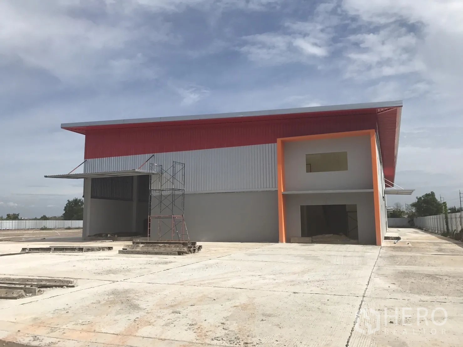 仓库 for sale in Sai Noi, Nonthaburi - 仓库正立面带装卸雨棚、办公室及宽阔混凝土场地。