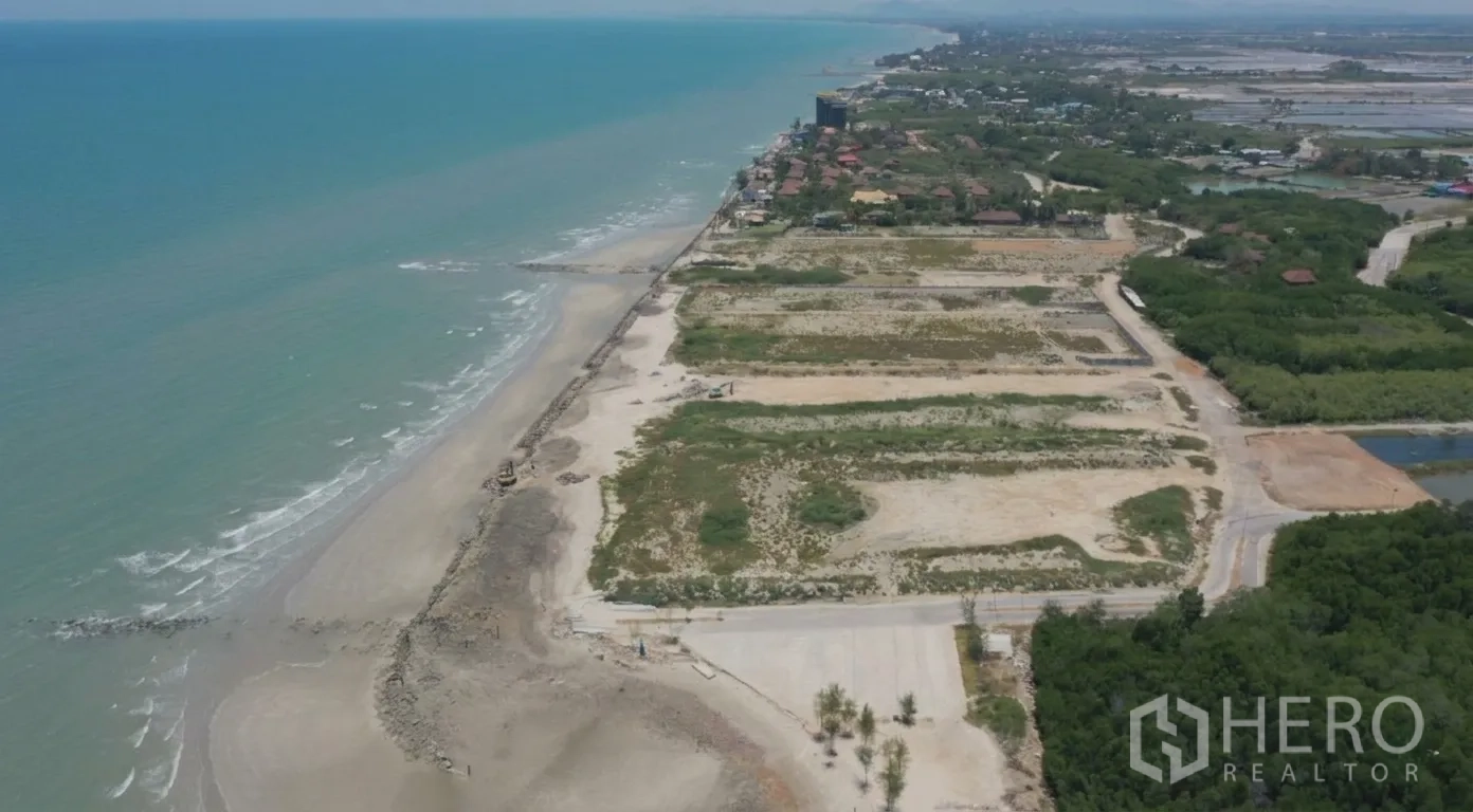 Land for rent or sale in Ban Laem, Phetchaburi - Aerial view of subdivided beachfront plots with road access along the coast.