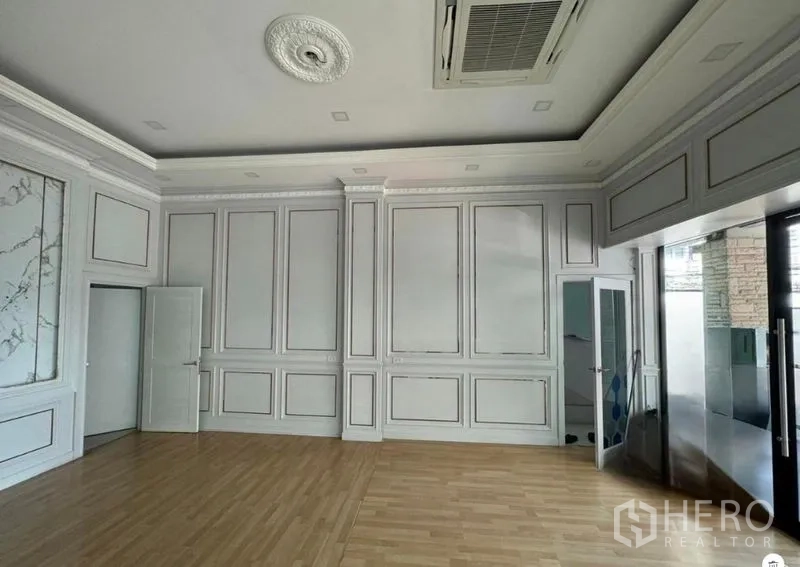 Office Space for rent in Prawet, Bangkok - Spacious office area featuring decorative wall mouldings, wood flooring and glass entrance doors.
