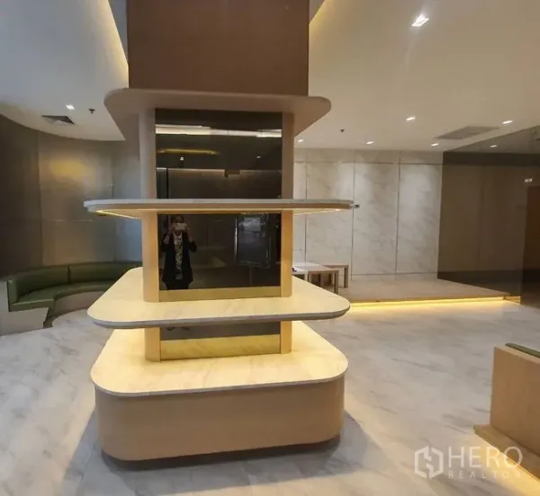 零售空间 出租在Bang Rak, Bangkok - 店内中央多层圆角展示台与大理石地面、筒灯照明。