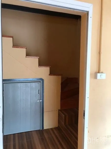 Warehouse for rent in Pak Kret, Nonthaburi - Under-stair storage cabinet beside a wooden staircase in the office area.