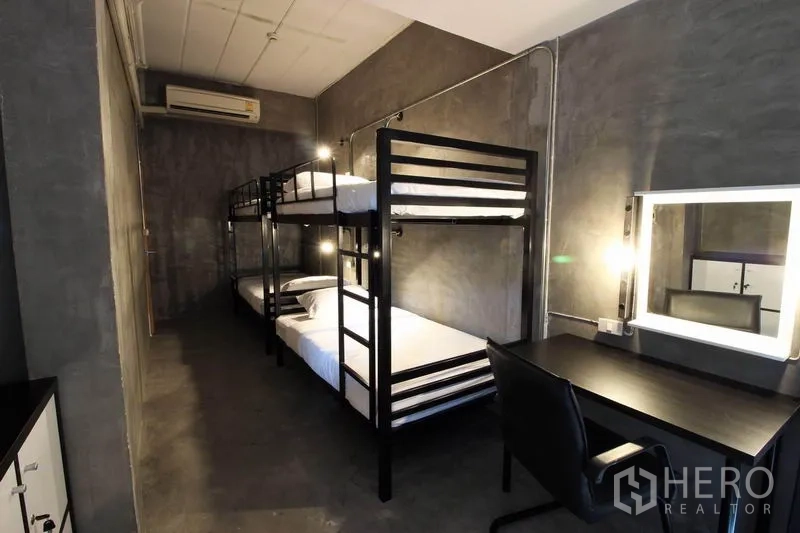 办公空间 出租或出售在Bang Rak, Bangkok - 宿舍式房间，黑色双层床与书桌。