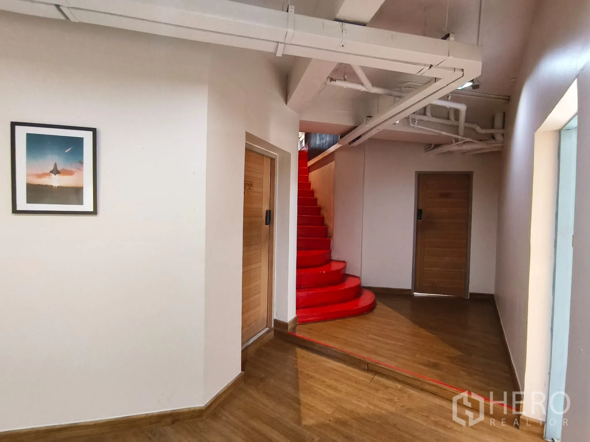 ตึกแถว for rent in Watthana, Bangkok - โถงทางเดินพร้อมบันไดวนสีแดงสดและประตูไม้.