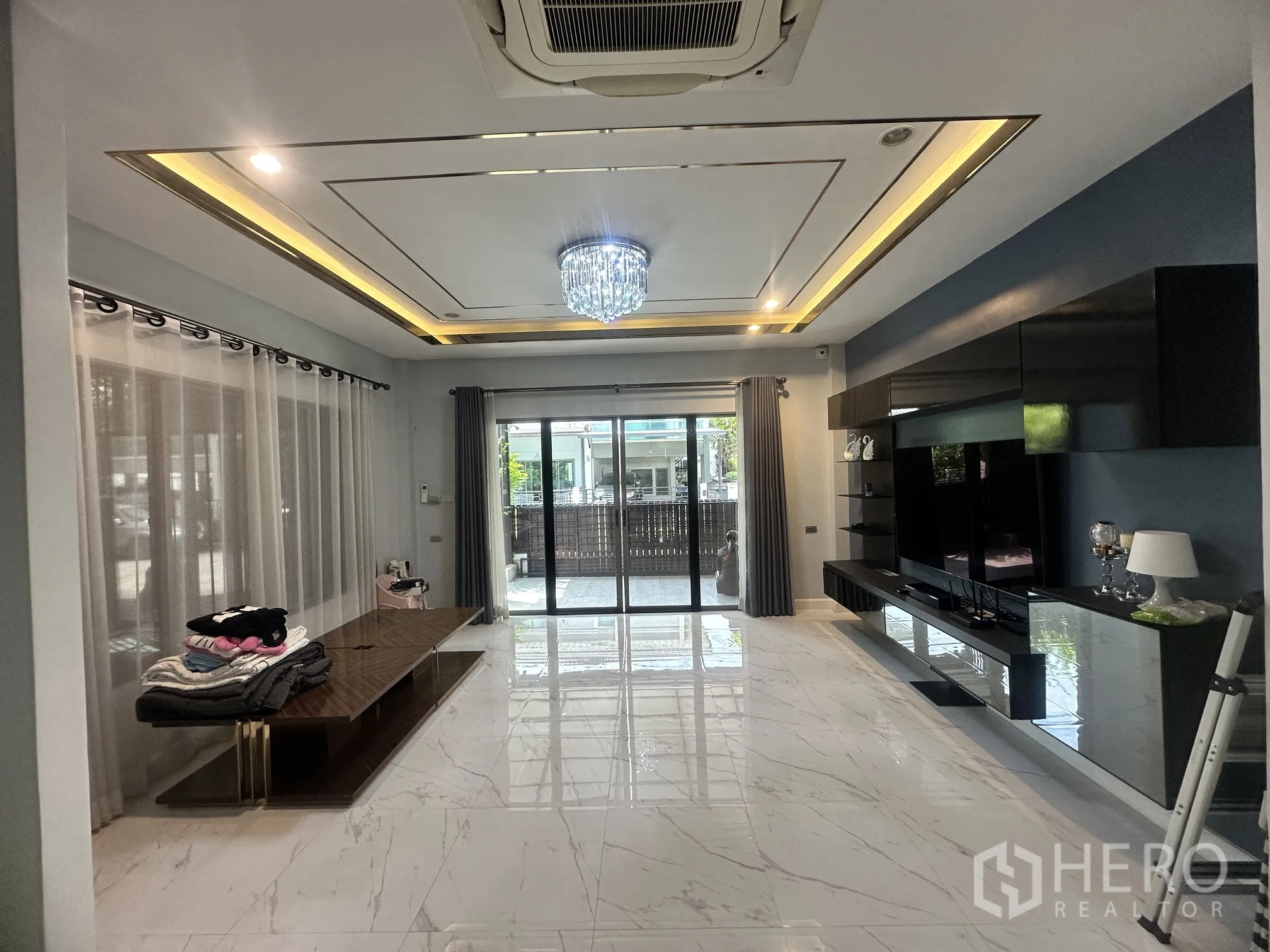 Detached House for sale in Pak Kret, Nonthaburi - Bright living room with sliding glass doors, media wall, and ceiling lighting.