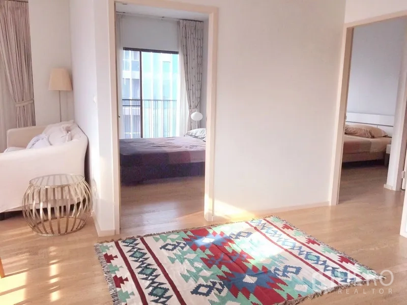 公寓 出租在Bangkok - 采光走廊铺彩色地毯，连接两间卧室与起居区。