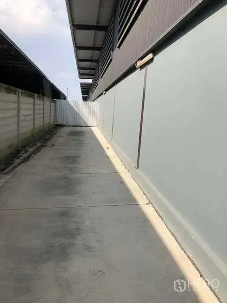 คลังสินค้า ให้เช่าในBang Phli, Samut Prakan - ทางเดินข้างอาคารพื้นคอนกรีตและกำแพงรั้วตลอดแนวโกดัง