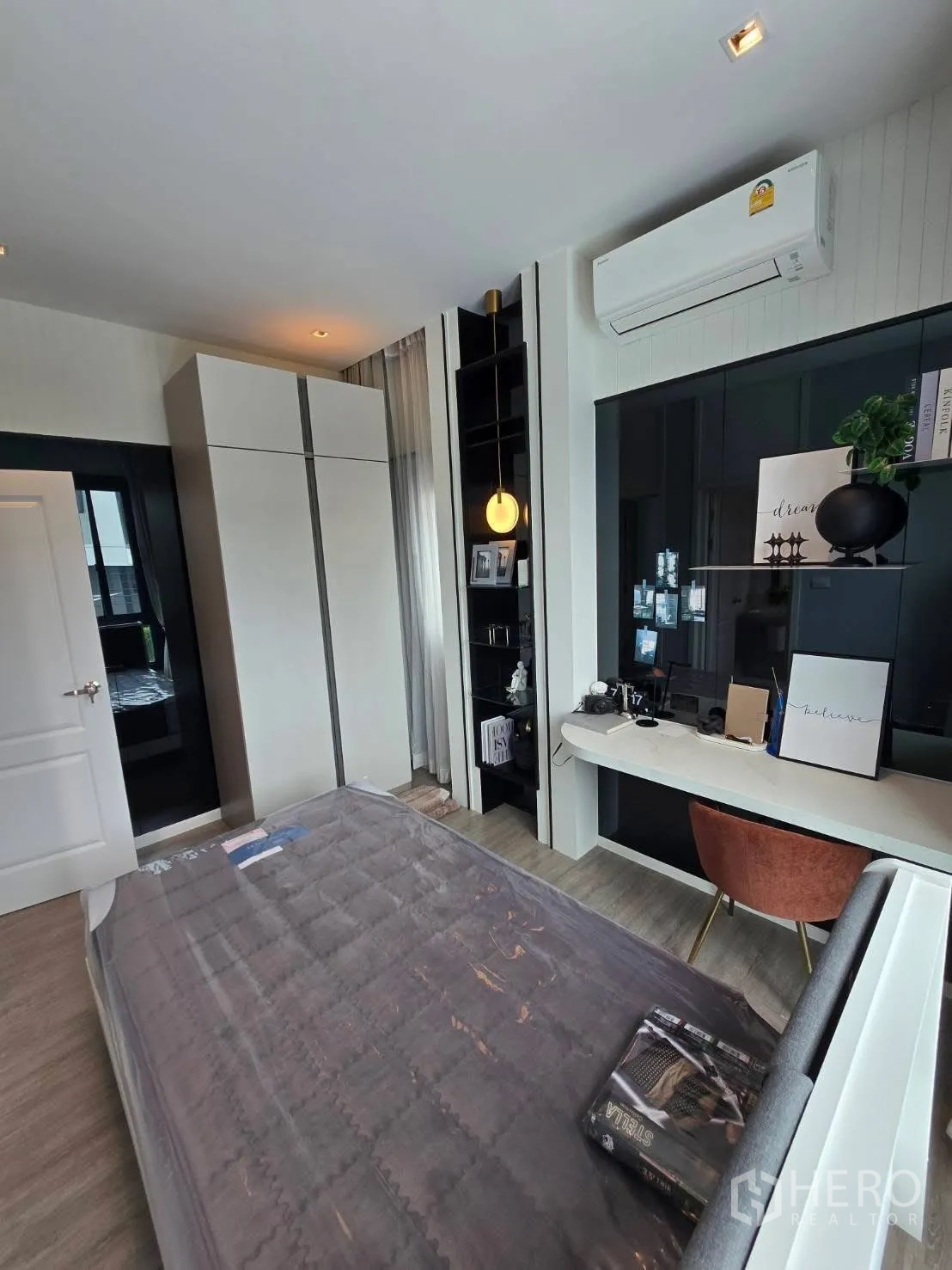 Semi-detached House for rent in Bang Phli, Samut Prakan - Guest bedroom with bed, work desk, shelving and air conditioner.