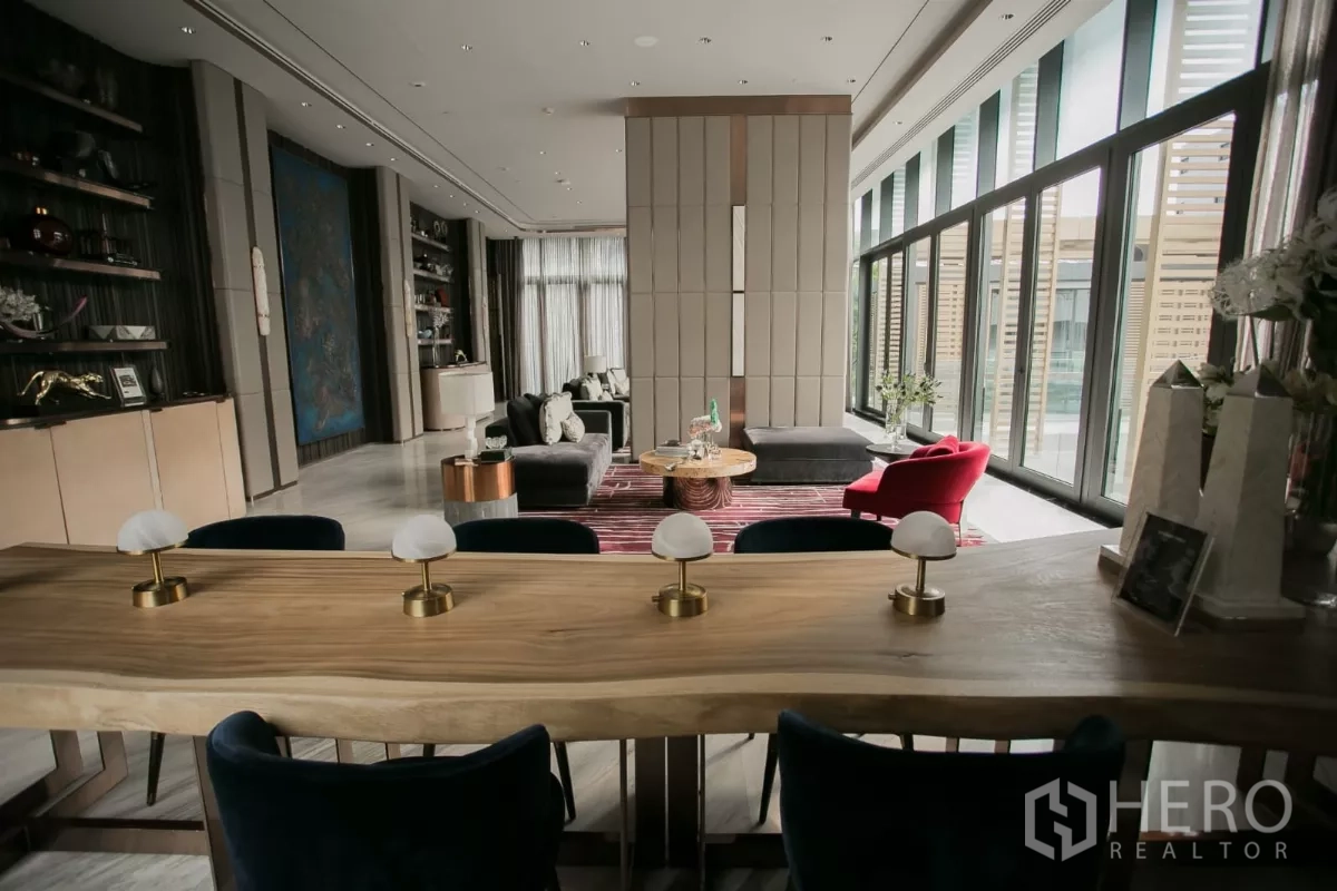 公寓 出租在Watthana, Bangkok - 住户社交室，原木长桌、开放置物架与沙发座。